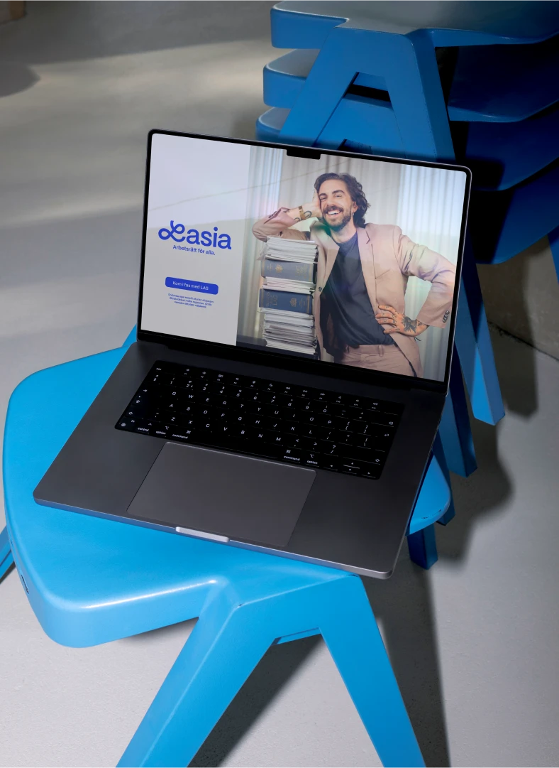Lasia – Arbetsrätt för alla. En laptop som står på en blå stol. Datorn är uppfälld och visar Lasias webbplats.