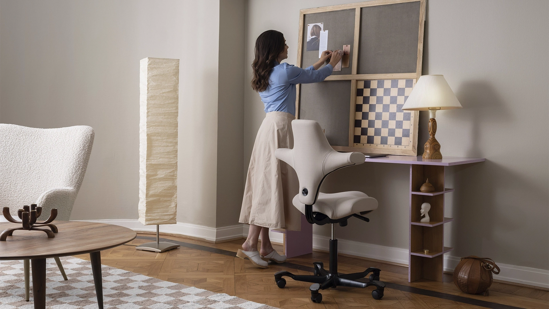 Livingroom calmly styled with white armchair and a desk and a white office chair