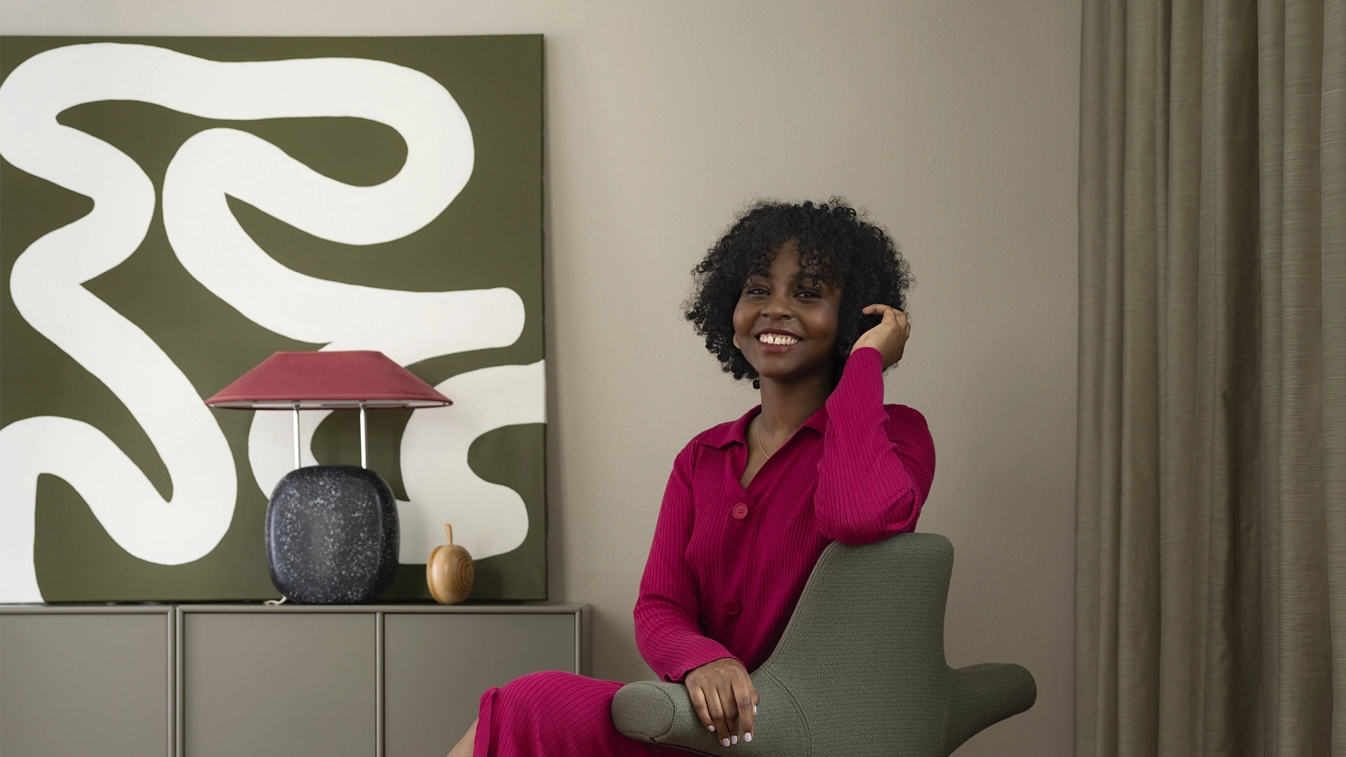 Woman sitting on a office chair smiling towards the camera