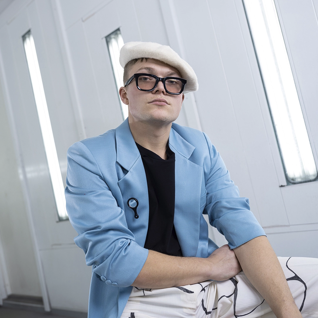 White room, guy with light blue blazer, white trousers and white beret, sunglasses - NyStudio