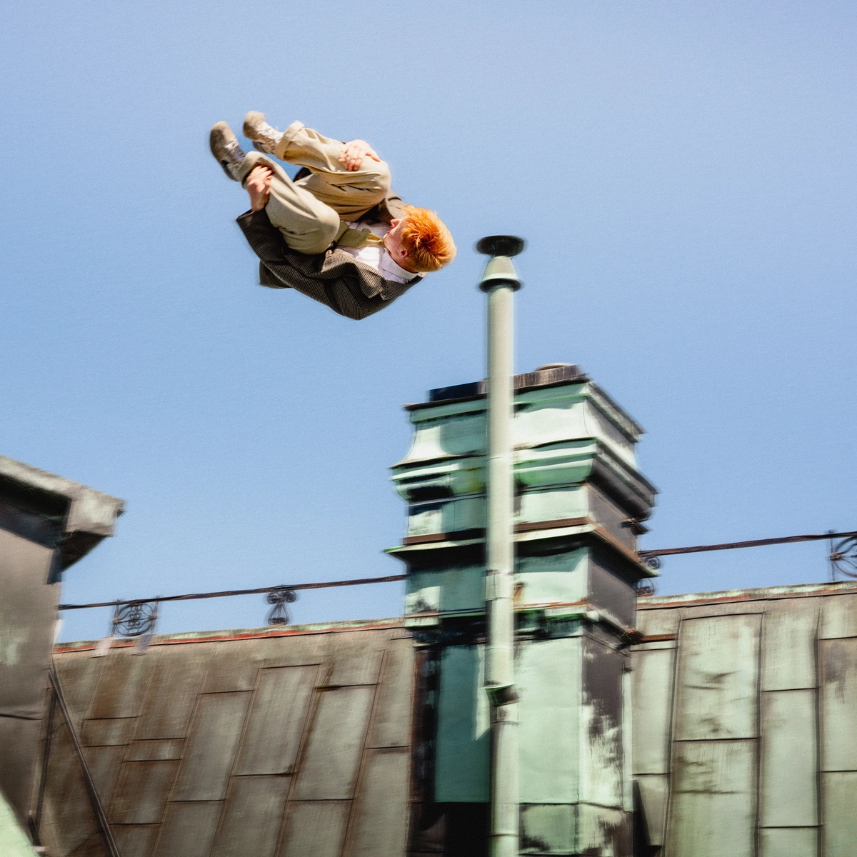 Man doing a flip on top of a roof