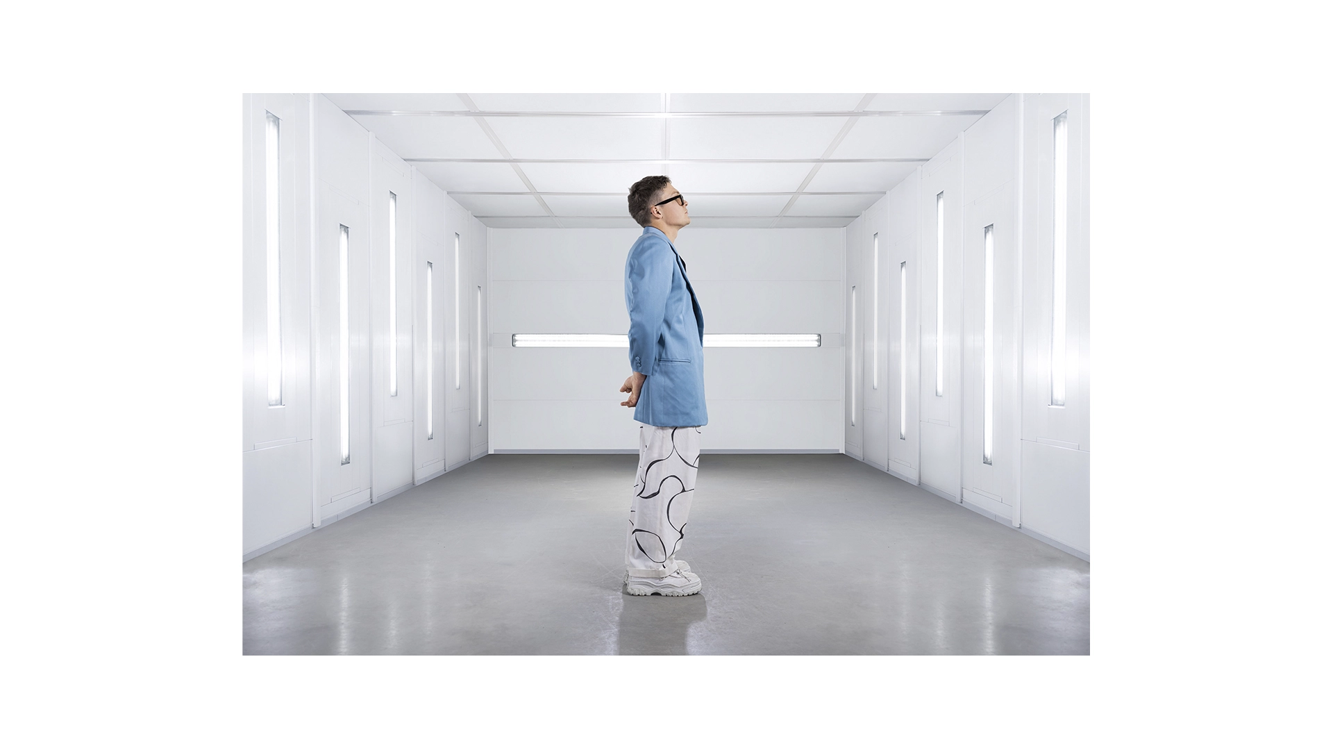 Side-profile of a guy with light blue blazer, white trousers and white beret, sunglasses - NyStudio