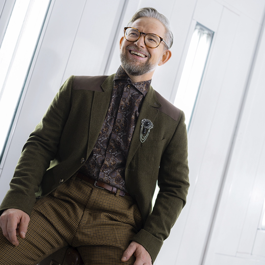 Picture of a guy in brown suit trousers brown blazer and a multicoloured shirt. All clothing items thrifted from PMU Second hand - Ny Studio