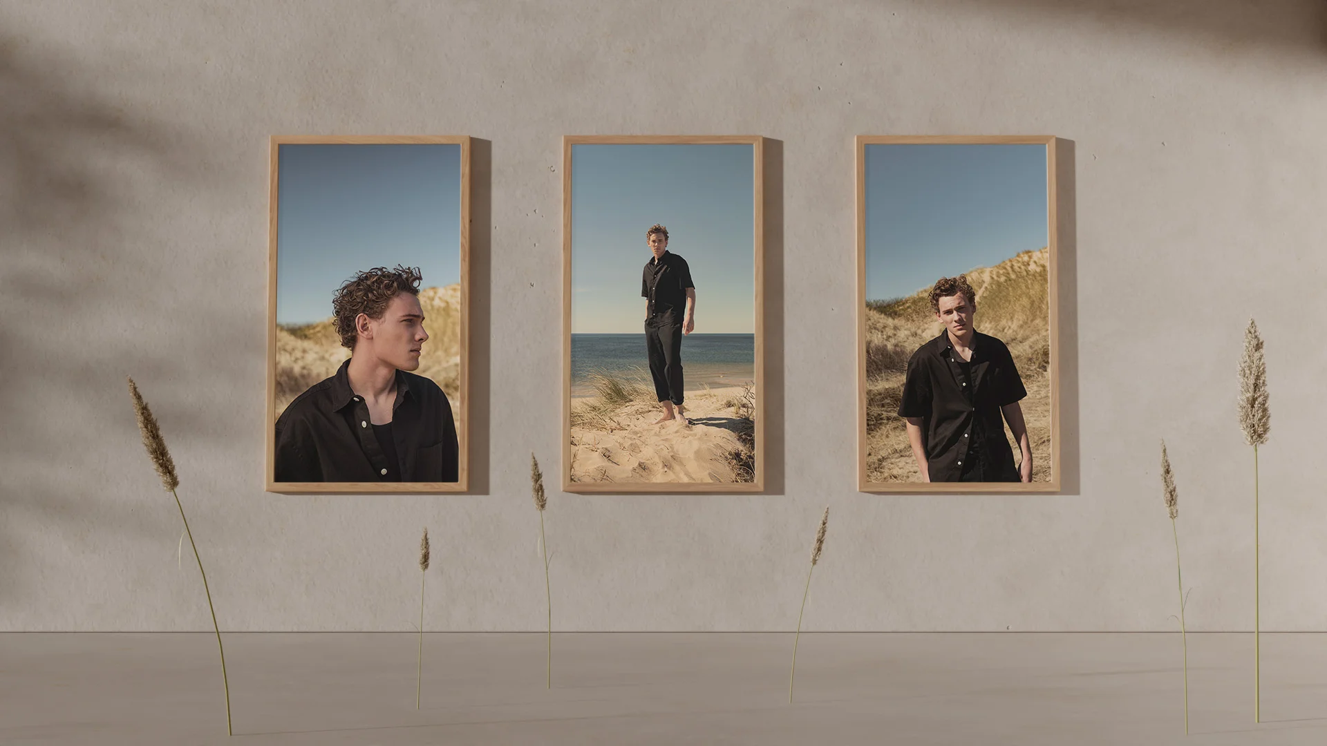 3 tavlor på en kille i svarta kläder på en strand i solen - Ny Studio