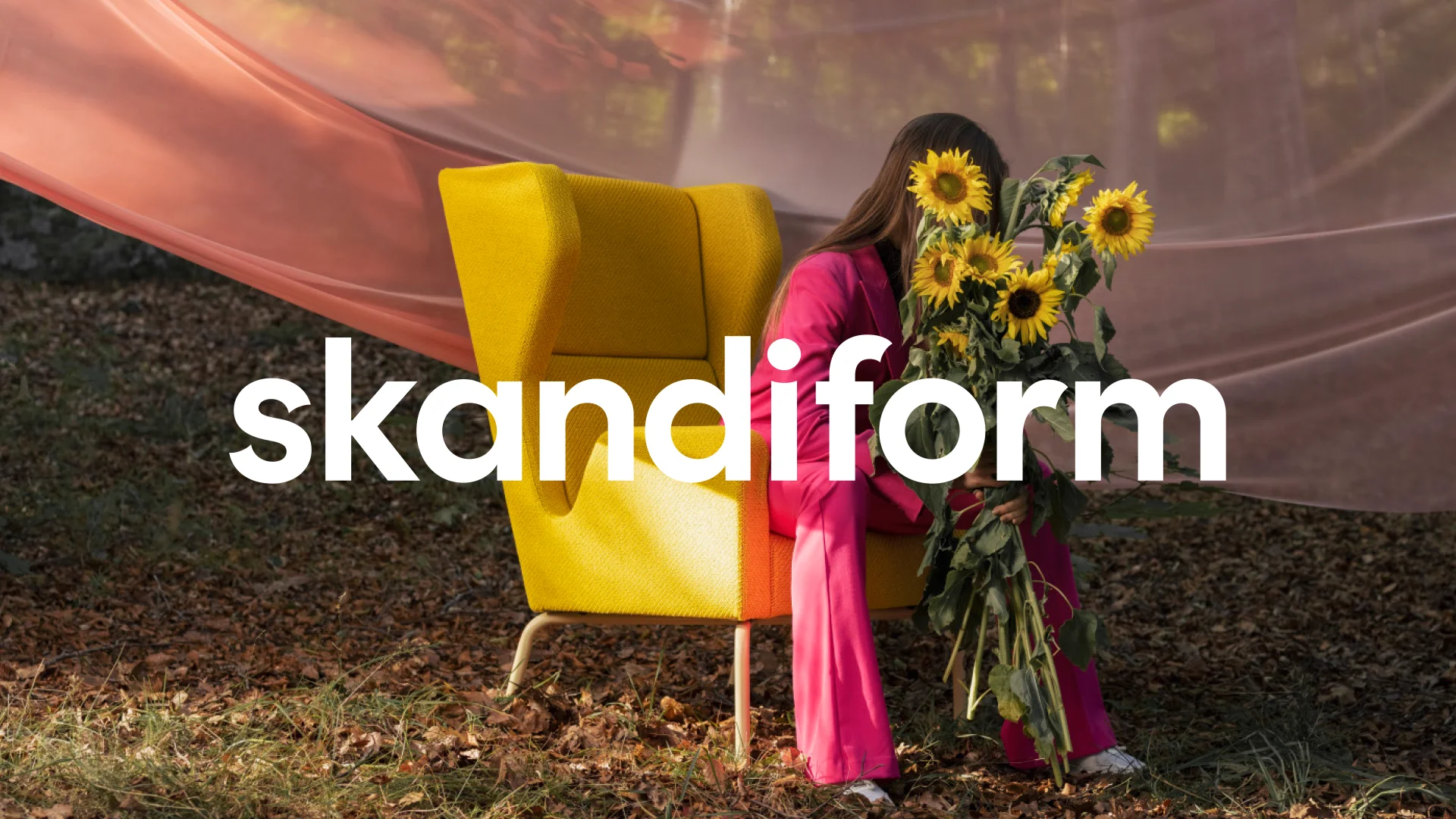 Skandiform logga framför en gul stol, tjej håller i solrosor sitter i stolen - Ny Studio